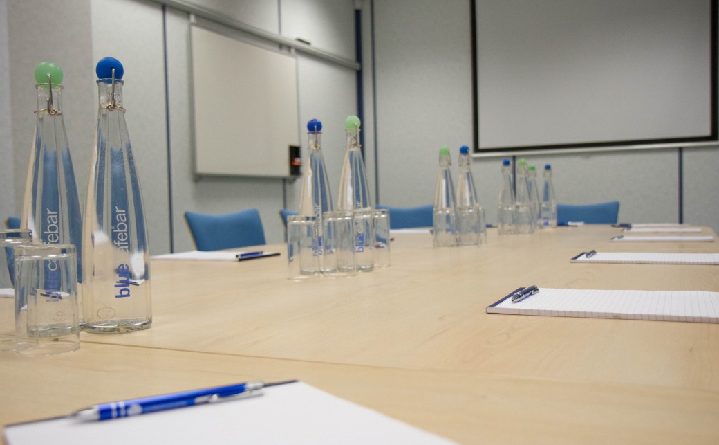 Shot of Garda room with notepads, pens, bottles of water and glasses on boardroom table at The Ark Conference Centre in Basingstoke Hampshire